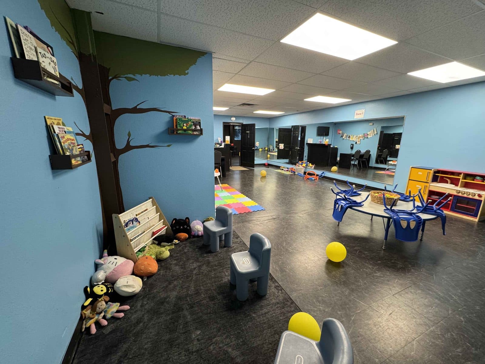 Onsite childcare room at Colorado Iron with reading nook and play tables