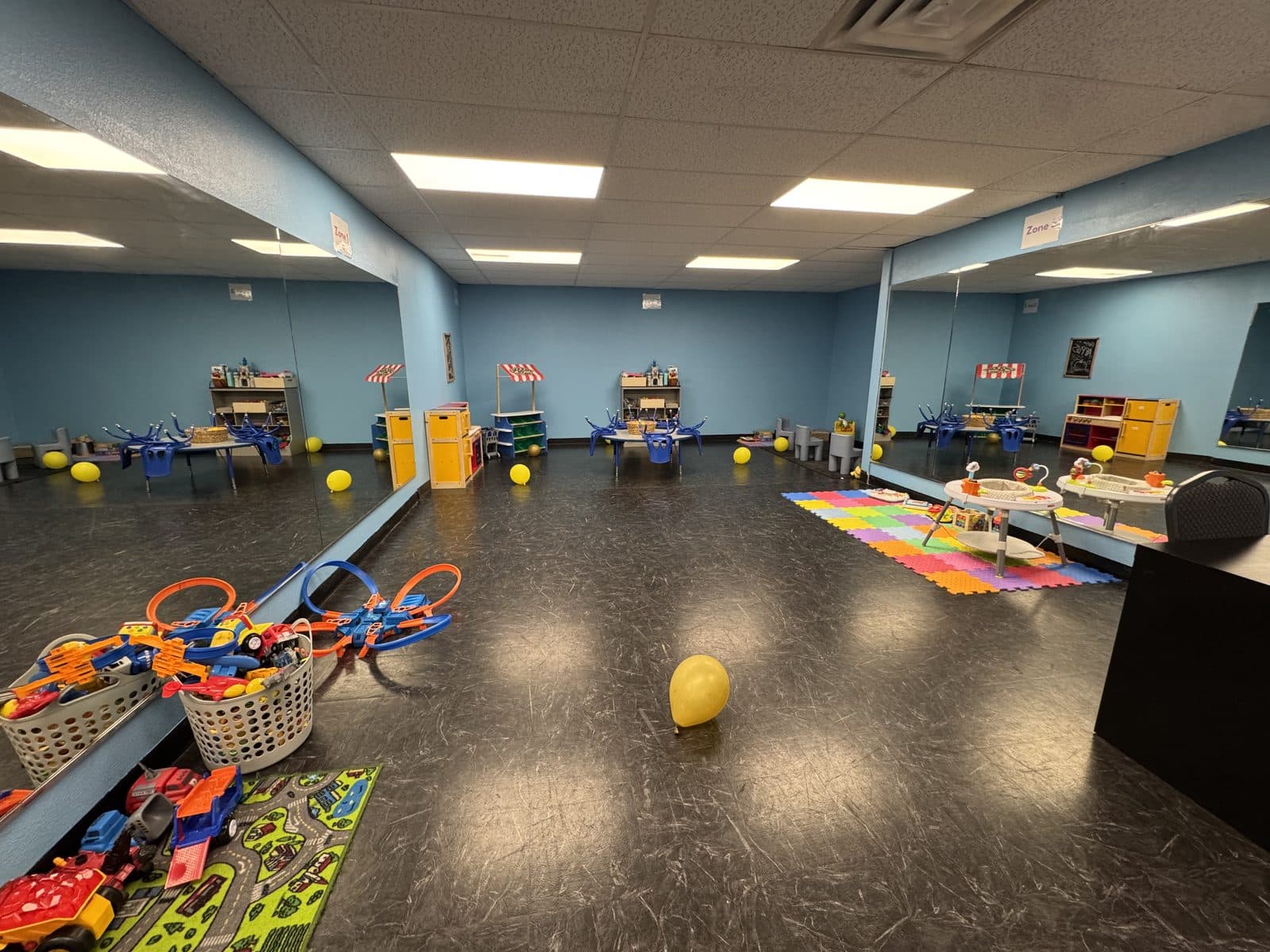 Open play area with toys and mats in the Colorado Iron childcare room